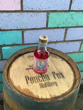 Load image into Gallery viewer, Bottle of Poncho Fox Pick Gin on a wooden barrel with colorful tiled background
